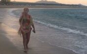 Teresa Guilherme passeia pela praia em biquíni