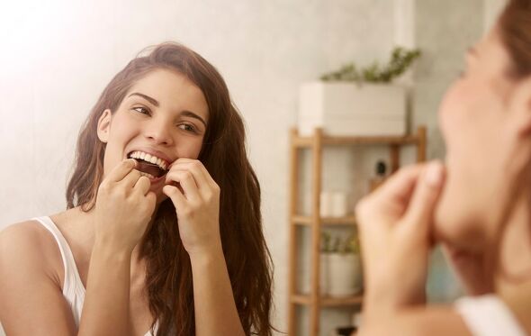 mulher, higiene oral, fio dentário