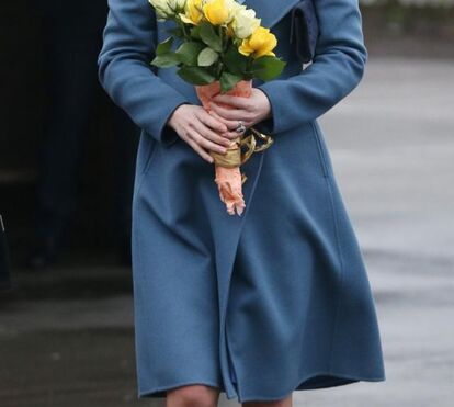 Grávida e sorridente, Kate encanta crianças em visita a escola