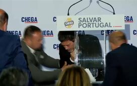 O momento em que André Ventura leva a mão ao peito e ao pescoço e cai inanimado no palco