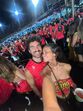 Pessoas celebram o carnaval com trajes vermelhos e penas azuis