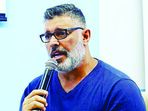 Homem de óculos fala ao microfone