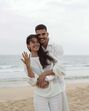 Casal celebra noivado na praia com um sorriso
