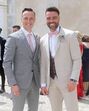 Dois homens posam sorrindo, vestidos para uma ocasião especial
