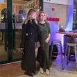 Duas mulheres posam em frente ao restaurante "Pró Sabor", sorrindo para a câmara