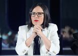 Mulher de óculos, blazer branco e batom vermelho