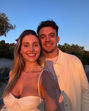 Casal sorri para a câmera com luz dourada, mostrando carinho