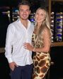Casal sorri para a câmara num ambiente elegante