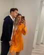 Um homem e uma mulher tiram uma selfie num espaço interior