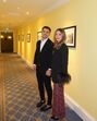 Um casal posa num corredor com obras de arte