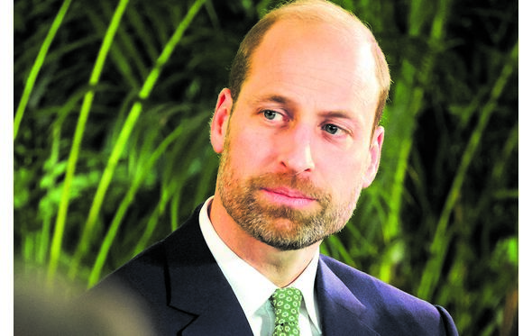 O príncipe William num evento, usa fato e gravata