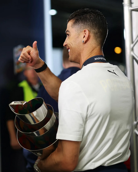Cristiano Ronaldo celebra vitória na Liga das Nações com troféu.
