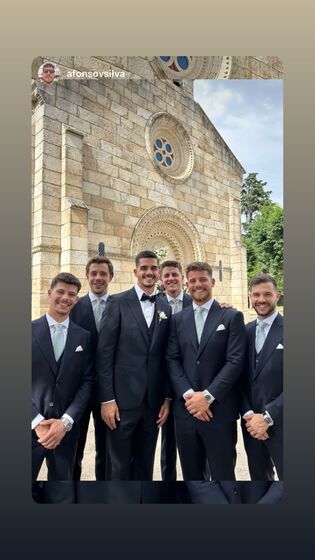 Um grupo de homens engravatados posa para foto em frente a igreja
