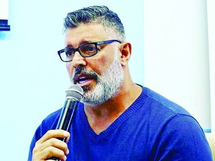 Homem de óculos fala ao microfone