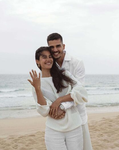 Casal celebra noivado na praia com um sorriso