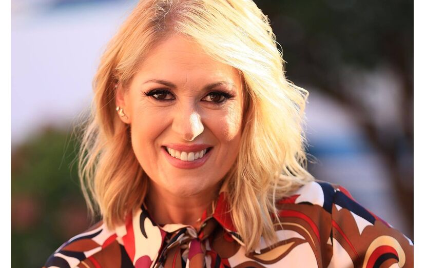 Retrato de Cristina Ferreira com uma camisa estampada e um sorriso no rosto
