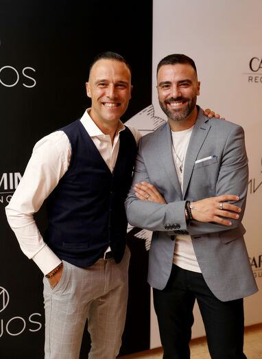 Dois homens sorriem para a câmara num evento