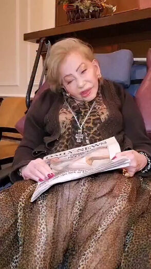 Mulher lê jornal com manchete "Daily News"