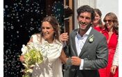 Casamento em dia soalheiro com noivos a sair da igreja sob uma chuva de bolhas de sabão