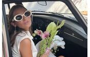 Kika Salema surge como uma "diva perfeita" num carro clássico, com um elegante vestido e flores.
