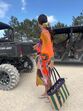 Mulher com vestido colorido junto a veículos todo-o-terreno