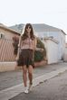Moda outono/inverno: mulher com saia castanha e blusa estampada