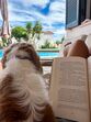 Um livro, um cão e uma piscina para um dia de descanso