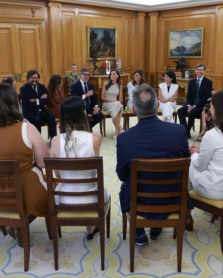 Reunião com a Rainha Letizia e um grupo de pessoas num ambiente formal