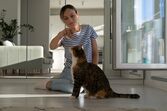 Mulher passa tempo com o seu gato em casa