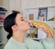 Mulher beija o seu dragão barbudo, um réptil ideal para donos de primeira viagem