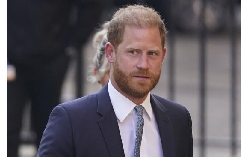 O príncipe Harry num fato azul-escuro e camisa branca