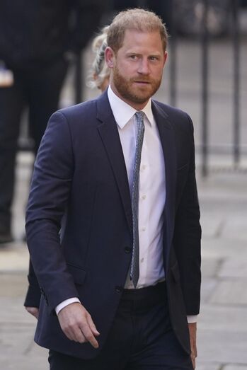 O príncipe Harry num fato azul-escuro e camisa branca