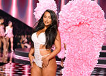 Modelo com lingerie branca e volumosas asas de flores cor-de-rosa no desfile Victoria's Secret em Nova Iorque