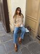 Moda com camisola sobre os ombros combinada com jeans e mocassins