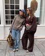 Duas amigas exibem looks de outono com tons terrosos e acessórios estilosos na rua