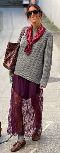 Mulher com camisola cinzenta e saia de renda, seguindo tendência da estação