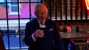 Carlos III bebe Guinness durante visita a cervejeira.
