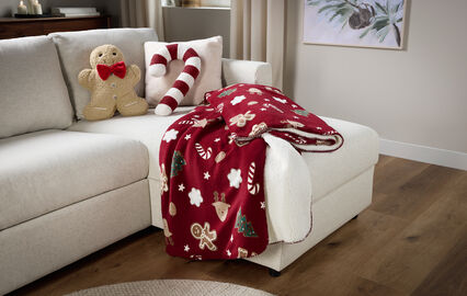 Decoração natalícia aconchegante com manta, boneco de gengibre e bengala de açúcar