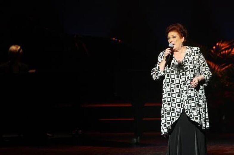 Anita Guerreiro atua num palco com um microfone na mão