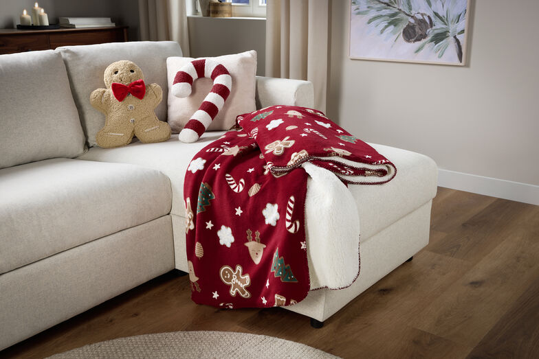 Decoração natalícia aconchegante com manta, boneco de gengibre e bengala de açúcar