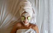 Bem-estar em foco: mulher relaxa com máscara facial e pepinos