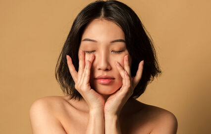 Mulher asiática com produtos de skincare coreana em promoção