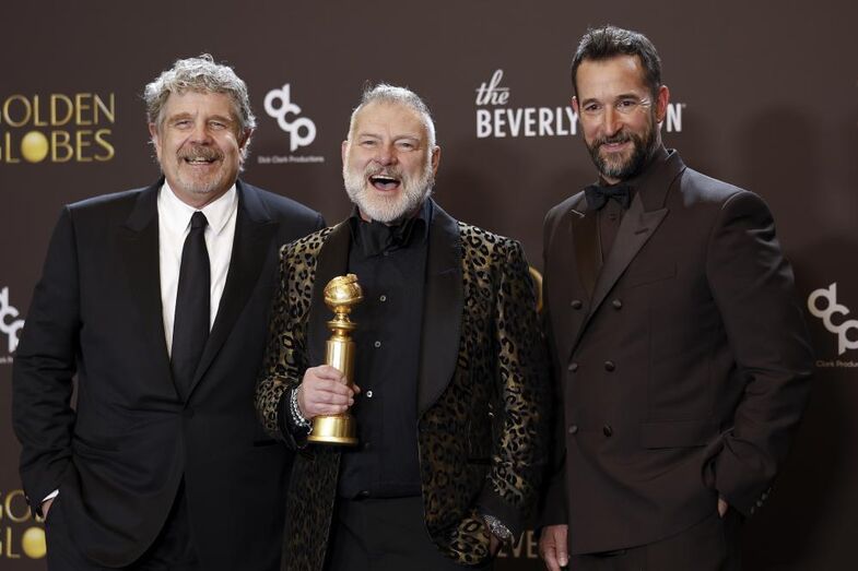 Os produtores John Wells e R. Scott Gemmill com o ator Noah Wyle exibem o troféu ganho por 'The Pitt' 