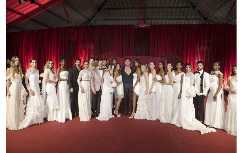 Modelos apresentam vestidos de noiva de Gio Rodrigues num desfile com figuras conhecidas