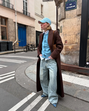 Tendências de primavera: look urbano em Paris com casaco comprido, ganga larga e apontamentos em azul.
