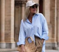 Tendências de primavera: mulher com camisa azul, calças e boné dos Yankees