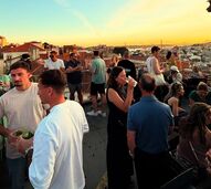 Pessoas aproveitam o sol numa esplanada em Lisboa com vista sobre a cidade