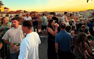 Pessoas aproveitam o sol numa esplanada em Lisboa com vista sobre a cidade