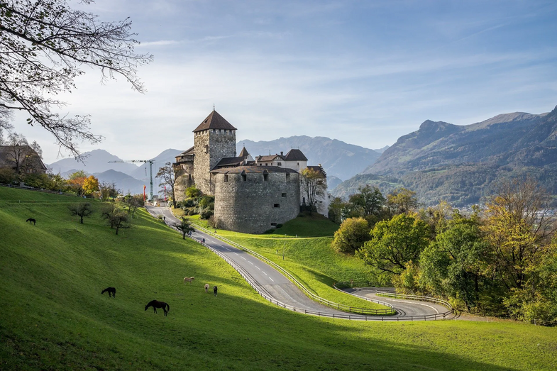Castelo de Vaduz, no Liechtenstein, com cavalos e vista para as montanhas