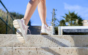 Pessoa a subir escadas com ténis, durante caminhada focada no bem-estar